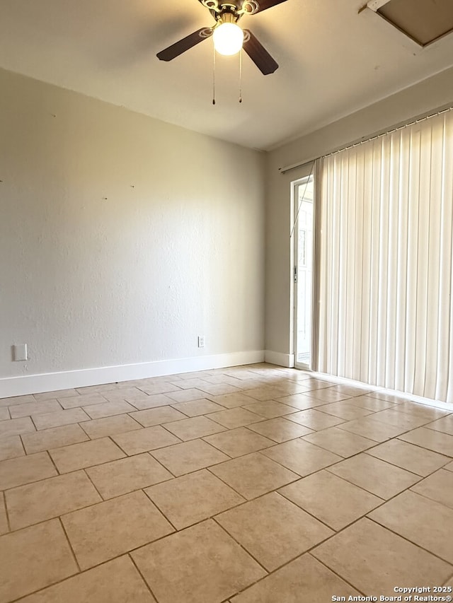 spare room with ceiling fan and light tile patterned flooring