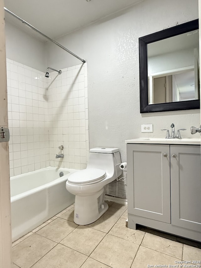 full bathroom featuring tile patterned floors, vanity, tiled shower / bath combo, and toilet