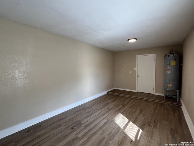 spare room with hardwood / wood-style floors and water heater