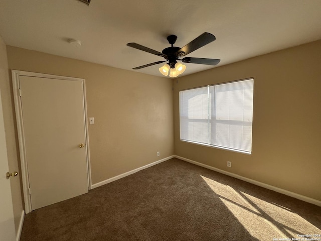 carpeted spare room featuring ceiling fan