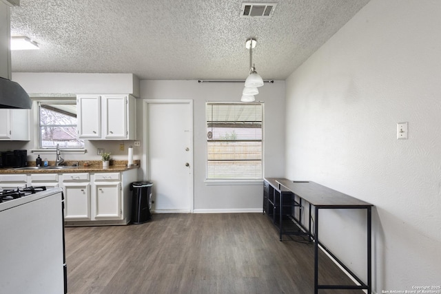 kitchen with white cabinetry, hanging light fixtures, white range with gas cooktop, and a textured ceiling