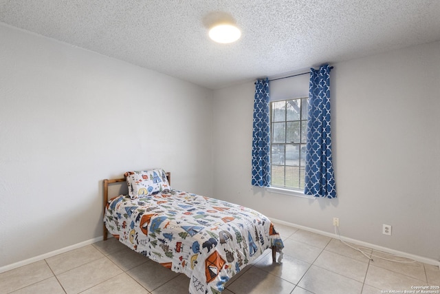 bedroom featuring light tile patterned floors and a textured ceiling