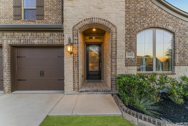 exterior entry at dusk featuring a garage