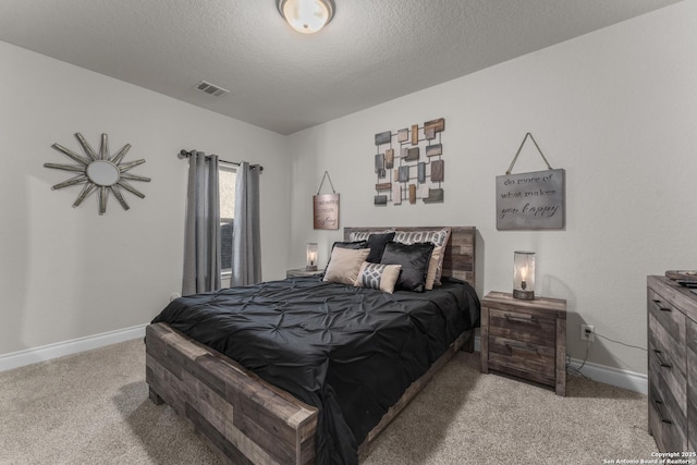 bedroom with light colored carpet and a textured ceiling