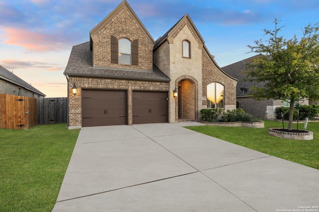 french country home with a yard and a garage