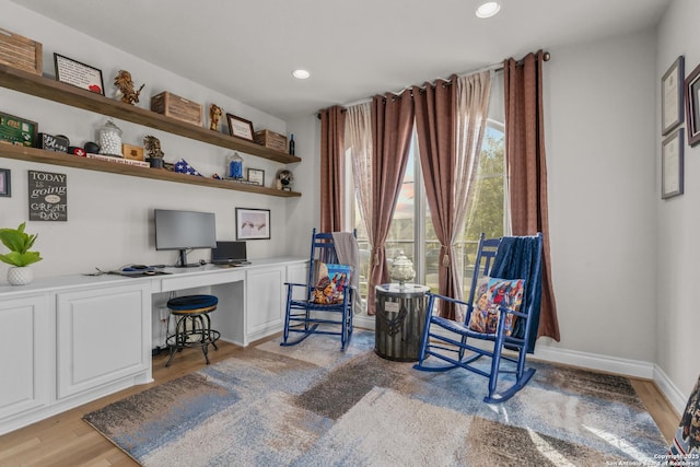 sitting room featuring built in desk and light hardwood / wood-style floors