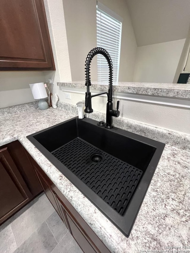 interior details with dark brown cabinetry and sink