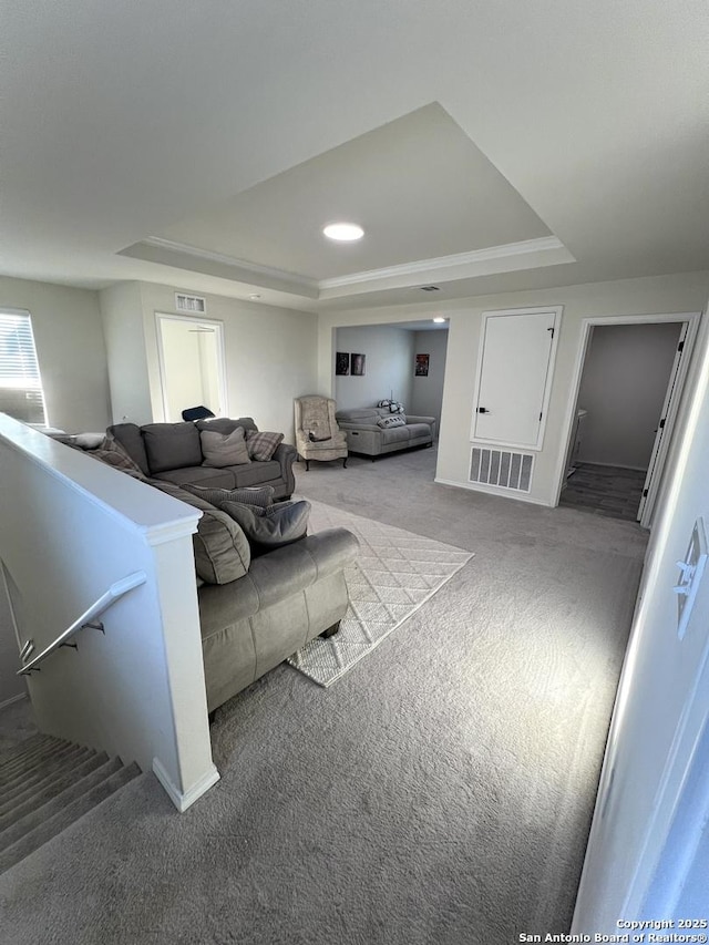 living room with a tray ceiling and light colored carpet