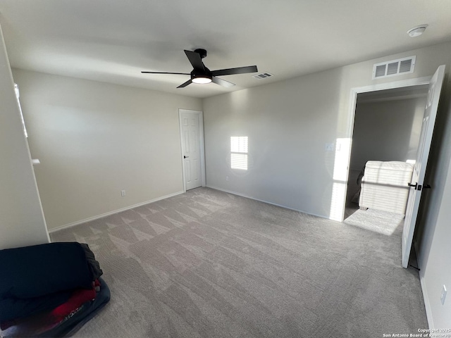 spare room featuring light carpet and ceiling fan