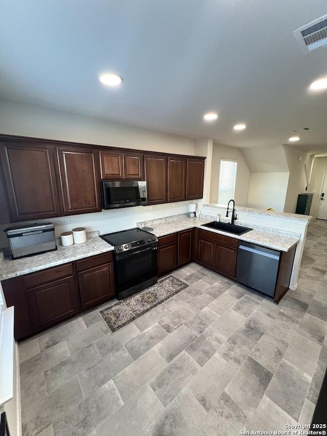 kitchen featuring kitchen peninsula, appliances with stainless steel finishes, dark brown cabinetry, and sink