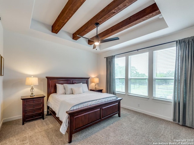 bedroom featuring ceiling fan, light carpet, and a tray ceiling