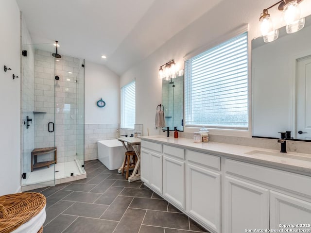 bathroom with vanity, plus walk in shower, tile patterned floors, vaulted ceiling, and tile walls