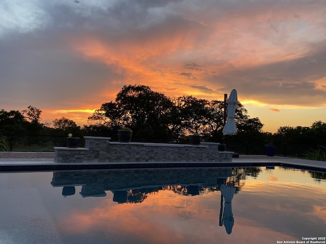 view of pool at dusk