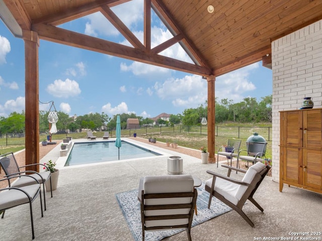 view of pool featuring pool water feature, a patio area, and a grill