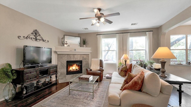 living room with a tile fireplace, hardwood / wood-style flooring, and ceiling fan