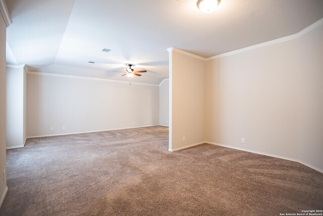 carpeted spare room featuring vaulted ceiling, ceiling fan, and crown molding