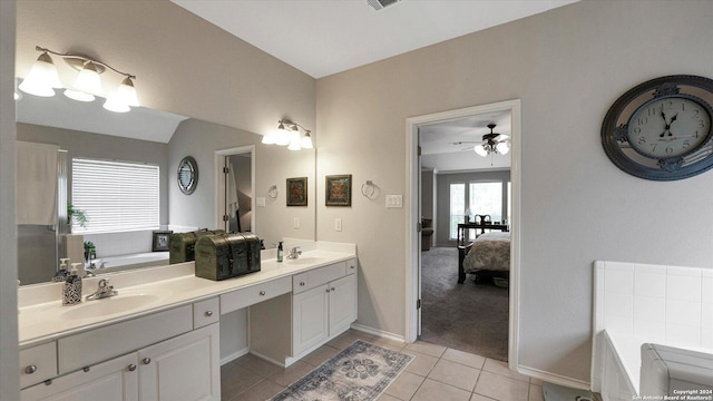 bathroom with tile patterned floors, ceiling fan, a bathtub, and vanity