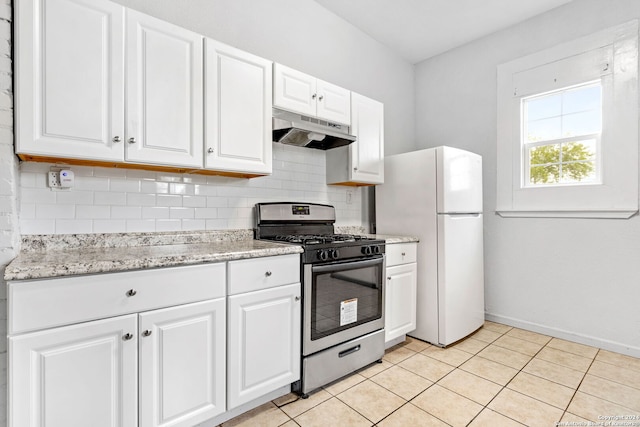 kitchen with stainless steel gas stove, white cabinets, light tile patterned floors, and white refrigerator