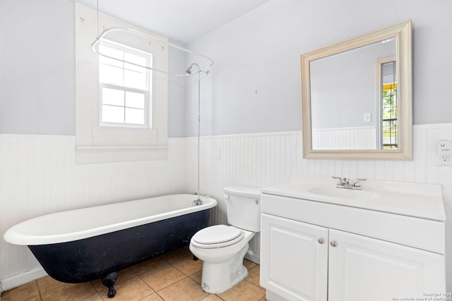 bathroom featuring tile patterned flooring, vanity, toilet, and a tub