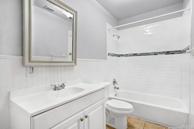 full bathroom with tiled shower / bath, tile patterned flooring, vanity, and toilet