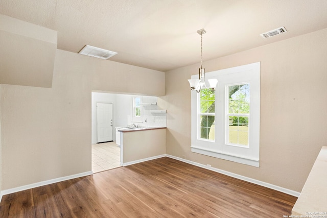 interior space with sink, light hardwood / wood-style floors, and a notable chandelier