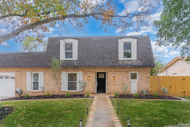 view of property featuring fence, an attached garage, a shingled roof, a front lawn, and brick siding