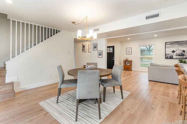 dining space featuring a notable chandelier and light hardwood / wood-style flooring