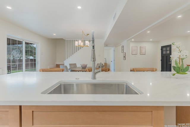 kitchen featuring light stone countertops and sink