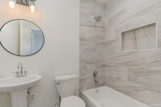 full bathroom with sink, tiled shower / bath, and toilet