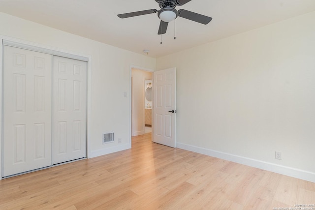 unfurnished bedroom with ceiling fan, light wood-type flooring, and a closet