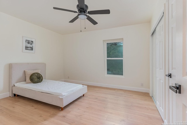 bedroom featuring ceiling fan, a closet, and light hardwood / wood-style flooring