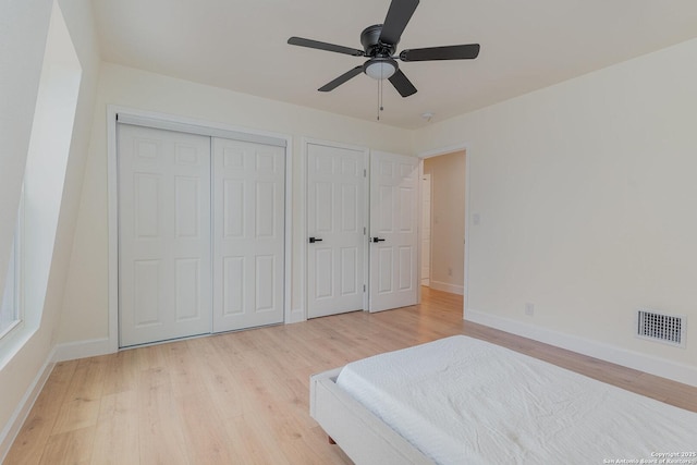 unfurnished bedroom with ceiling fan, two closets, and light hardwood / wood-style flooring