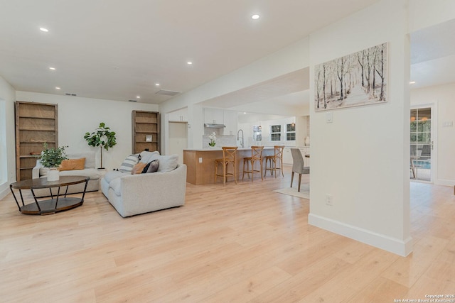 living room featuring light hardwood / wood-style floors and sink