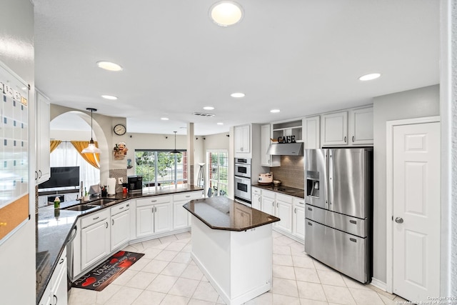 kitchen featuring sink, stainless steel appliances, backsplash, kitchen peninsula, and white cabinets