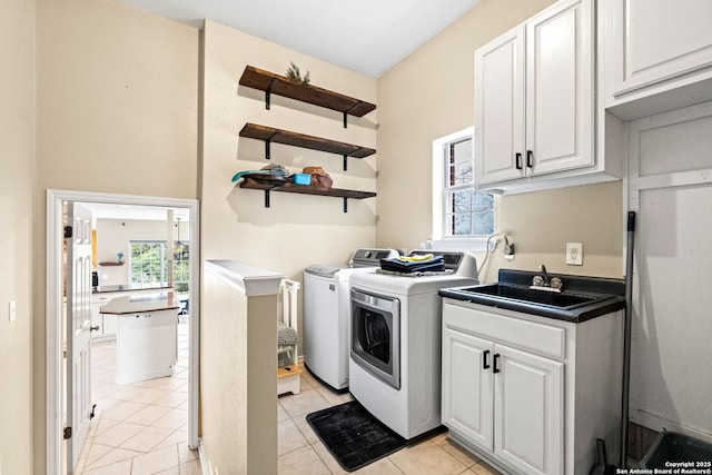 washroom featuring washer and clothes dryer, light tile patterned flooring, cabinets, and sink