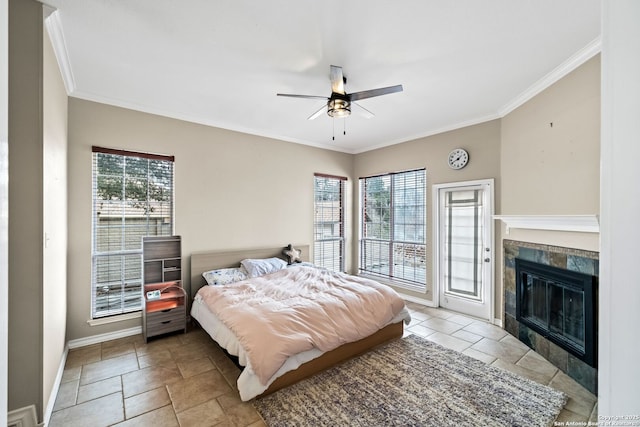 bedroom with multiple windows, access to exterior, ceiling fan, and a fireplace