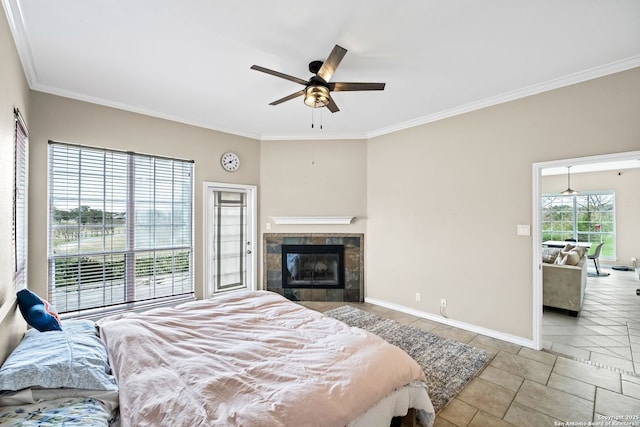 bedroom with multiple windows, ceiling fan, a tile fireplace, and ornamental molding