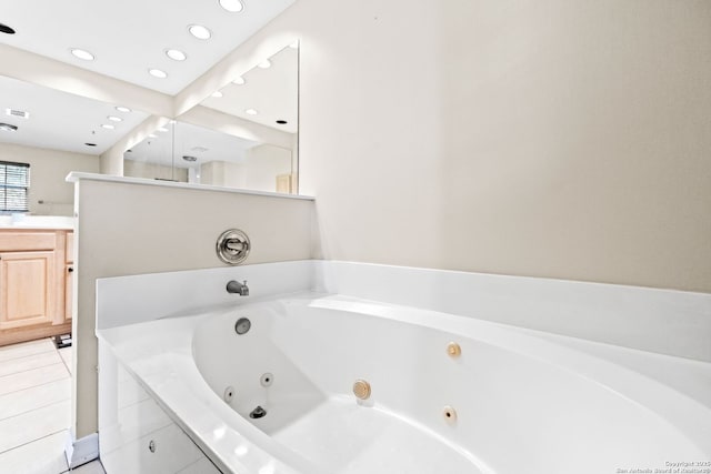 bathroom with tile patterned floors, vanity, and a relaxing tiled tub