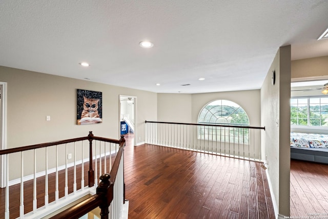 hall featuring a textured ceiling and dark wood-type flooring