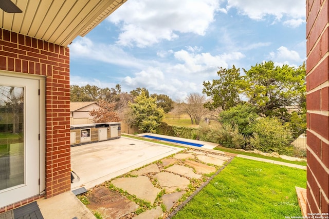 view of patio with a pool and exterior kitchen