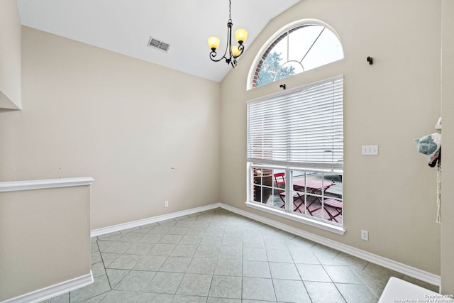 spare room featuring a notable chandelier, light tile patterned flooring, and lofted ceiling