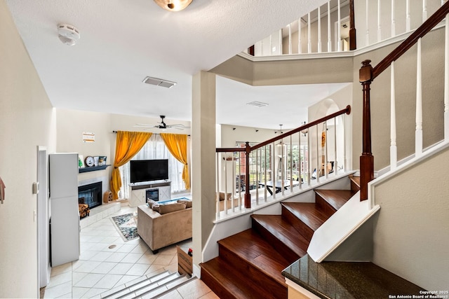 stairs featuring tile patterned flooring and ceiling fan