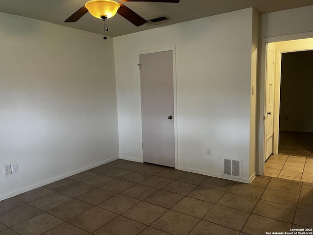 tiled empty room featuring ceiling fan