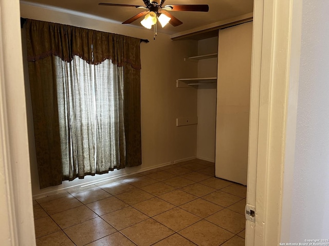 unfurnished bedroom with ceiling fan, a closet, and light tile patterned floors