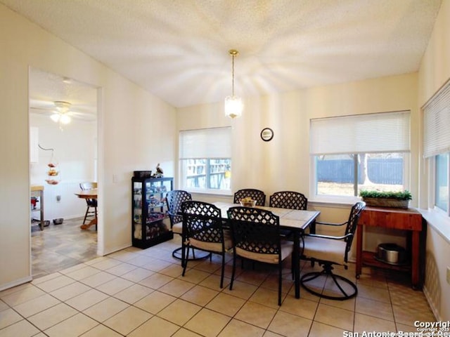 dining space with ceiling fan, light tile patterned floors, and a textured ceiling