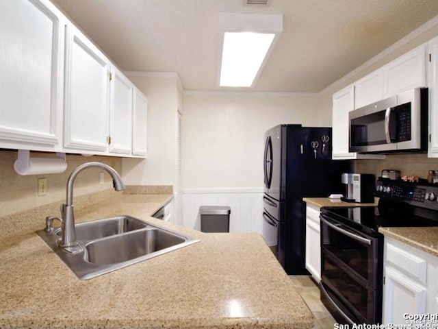 kitchen with white cabinets, black range with electric stovetop, crown molding, and sink