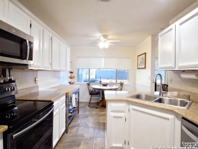 kitchen with sink, white cabinets, stainless steel appliances, and a textured ceiling