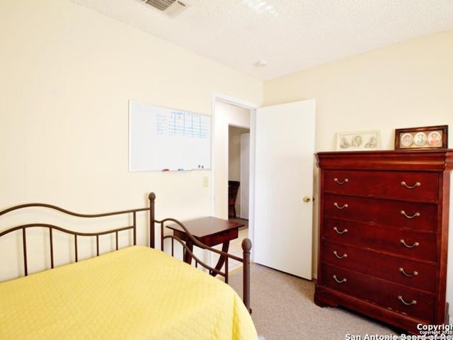 carpeted bedroom featuring a textured ceiling