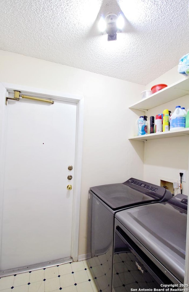 laundry area with a textured ceiling and washing machine and clothes dryer