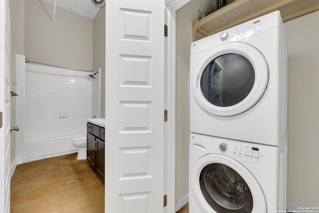 laundry room with light tile patterned floors and stacked washer and clothes dryer